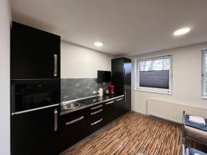 布伦瑞克索尔之家公寓的一间黑色的厨房,配有水槽和窗户
