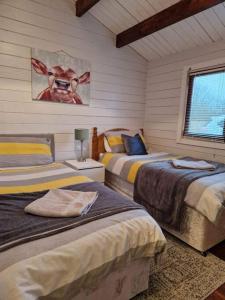 沃特福德The Log Cabin的卧室配有两张床,墙上挂着一幅画