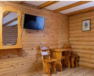 斯拉夫西克ВІДЕНЬ的小木屋设有桌子和墙上的电视