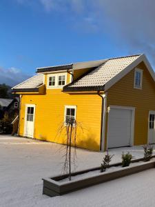 沃斯Sandvik Garasjeloft的车道上设有车库的黄色房子