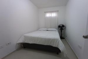 巴兰基亚Ayenda Brisas del Rio的白色的卧室设有床和窗户