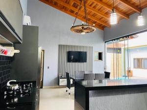伊瓜苏Casa Privativa na Av. Garibaldi Vila A的一个带黑色台面的厨房和一间客厅