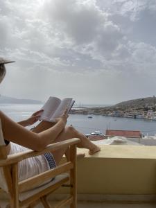 哈尔基岛Marina Castellana Studios的坐在椅子上读书的女人