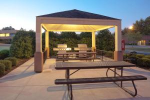普莱诺Sonesta Simply Suites Plano Frisco的凉亭配有长椅和野餐桌