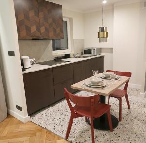 华沙Falcon Apartment Center 1 Warszawa Centralna的带桌子和两把椅子的厨房以及带水槽的厨房