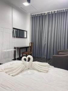 Pasir MasAainaa Villa Homestay的两个天鹅躺在床上