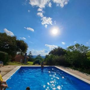 洛斯科克斯Faraway's Bed & Breakfast的蓝色的游泳池,阳光在天空中