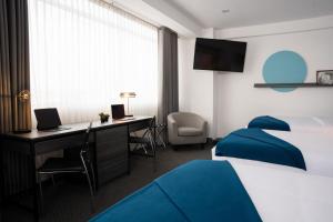 阿雷基帕QASA by NOMAD的酒店客房配有书桌和床。