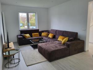 布鲁塞尔Villa Bed & Garden的客厅配有棕色沙发和黄色枕头