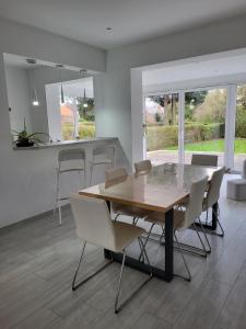布鲁塞尔Villa Bed & Garden的一间带木桌和白色椅子的用餐室