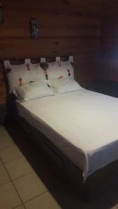 La TrinitariaYatzil的一张带白色床单和枕头的床