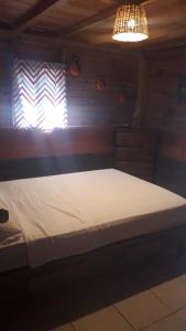La TrinitariaYatzil的一张大床,位于光线充足的房间内