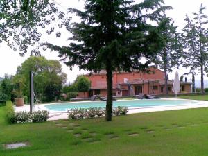 塞尔苏里格Belvilla by OYO Quattro Orcia的庭院里一座带树的大型游泳池