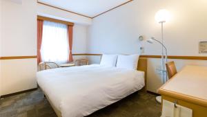 久留米市Toyoko Inn Nishitetsu Kurume eki Higashi guchi的酒店客房设有白色的床和窗户。