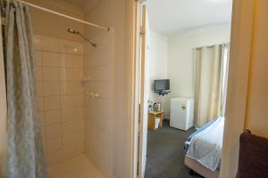 诺斯曼Great Western Motel Norseman的带淋浴的浴室和客房内的一张床