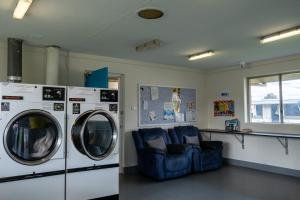 Middle SwanBIG4 Perth Midland Tourist Park的一间设有两台洗衣机和蓝色沙发的房间