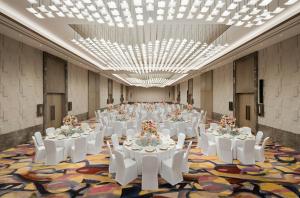 上海上海西岸美高梅酒店的一个带白色桌子和白色椅子的大型宴会厅