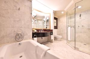 曼谷曼谷拉差达瑞士酒店的带浴缸、盥洗盆和卫生间的浴室