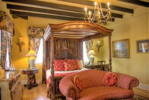 圣奥古斯丁Casa De Solana Bed and Breakfast的一间卧室配有天蓬床和沙发