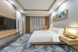 胶州青岛胶东国际机场秋临悦享酒店的一间酒店客房,配有一张大床和一台平面电视