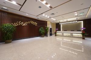 胶州青岛胶东国际机场秋临悦享酒店的大堂设有种植了盆栽植物的等候区