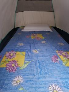 El Nido Beach Camp的一张床上,床上有鲜花,有蓝色的毯子