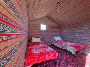 瓦迪拉姆Wadi rum galaxy camp的一间带两张床的卧室,位于一个天花板的房间