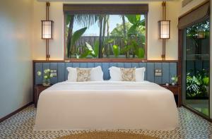 暹粒WAKA VILLA Private Resort & Spa - Adults Only的卧室设有一张白色大床和大窗户