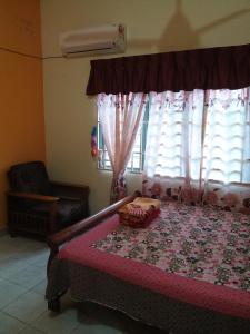 Paya Rewak达雅因迪娜民宿的一间卧室设有一张大床和一个窗户。