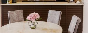 金马仑高原SPRINGHILL RESORT的一张桌子上带两把椅子的粉红色花瓶