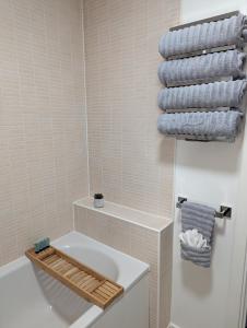 马斯顿格林Modern 2 Bed house - HS2, NEC & Birmingham Airport的浴室配有白色浴缸、卫生间和毛巾。