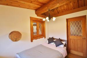 伊东Log cabin Izukogen - Vacation STAY 61056v的一间卧室设有一张床和木制天花板