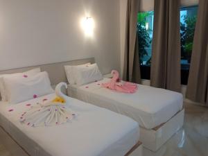 图杜Thoddoo Garden inn的两张带粉红色火烈鸟的床