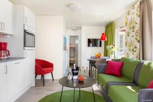 奥胡斯First Camp Åhus-Kristianstad的客厅配有绿色沙发和桌子