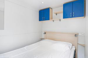 奥胡斯First Camp Åhus-Kristianstad的小房间设有蓝色橱柜和一张床