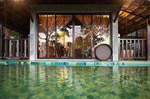 浮罗山背宝胜榴莲农场酒店的一座游泳池,旁边设有网球拍