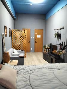 大阪Backstage Party Hostel & Bar的一间卧室设有一张床和一间客厅。