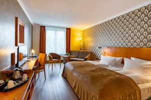 格尔利茨格尔利茨酒店的配有一张床和一张书桌的酒店客房