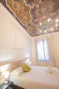 诺瓦拉Hotel Tornielli 9的一间卧室配有一张带彩绘天花板的床