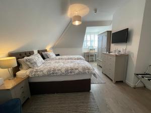 赛伦塞斯特Cotswold Hare的一间卧室配有一张床、梳妆台和电视。