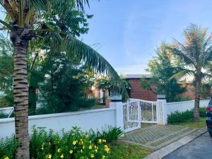 河静Hoa Tien Paradise Villa的白色围栏和棕榈树的房子