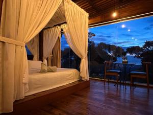 浮罗山背宝胜榴莲农场酒店的一间卧室设有一张床和一个大窗户