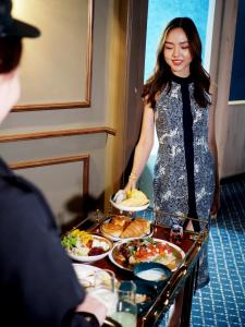 曼谷The Coach Hotel Sukhumvit - Asok BTS Bangkok by Compass Hospitality的站在食物自助餐前的妇女