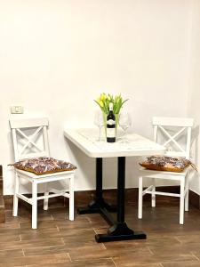 阿拉德Ultracentral Apartment的一张带两把椅子的白色桌子和一瓶葡萄酒