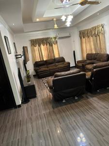 库马西BENJI'S VILLA的客厅配有真皮沙发和电视