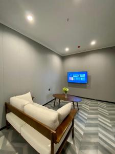 奥尔莫克Fan's Hotel- Ormoc的客厅配有沙发和墙上的电视