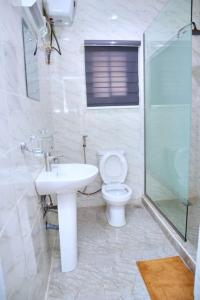KarsanaLush Meadows Apartments的浴室配有卫生间、盥洗盆和淋浴。