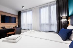 斯塔加德什切青Kyriad Stargard的酒店客房设有两张床、一张桌子和一台电视。