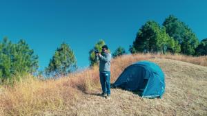 KandāghātSecret Staycation Nature Cottages的一名男子在帐篷旁边拍张照片