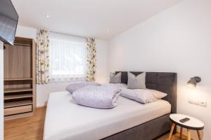 尼德泰Apart Auszeit的卧室配有一张带紫色枕头的大型白色床。
